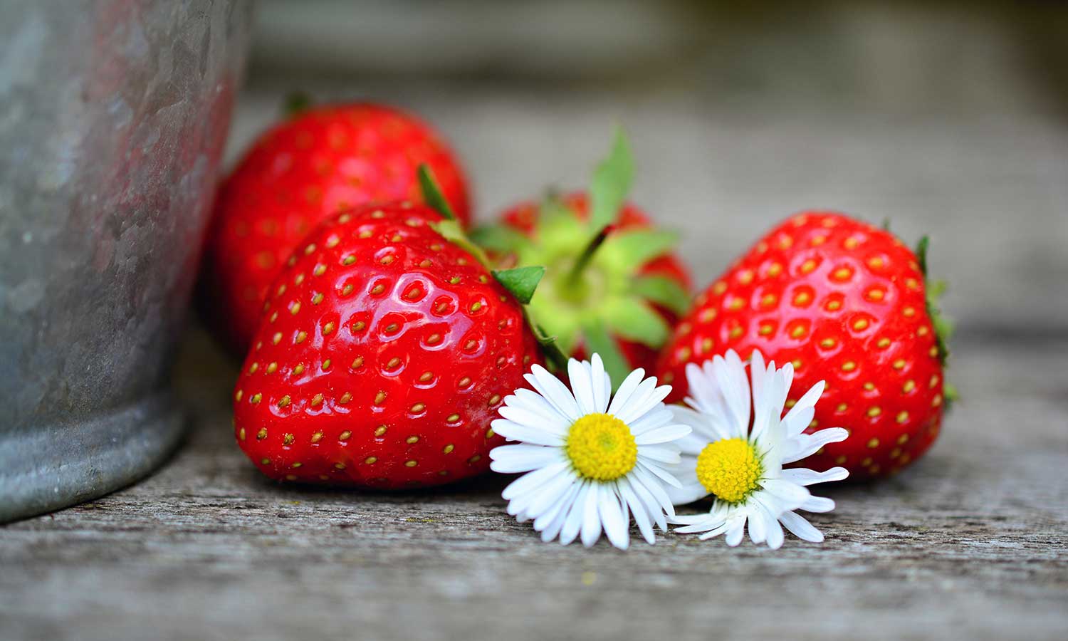 Erdbeeren und Blumen auf einem Gartentisch